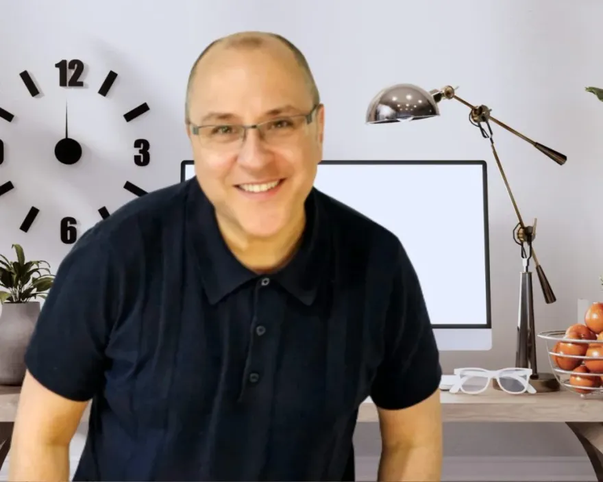 Stephen Stanton, Clinical Hypnotherapist, smiling at his desk in Stockport